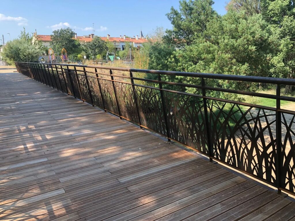 Tablero y barandillas caladas de la pasarela sobre el río La Basse